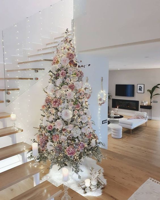a beautiful and delicate flocked Christmas tree with white, blush, mauve faux blooms, lights and twigs is a very romantic and refined idea