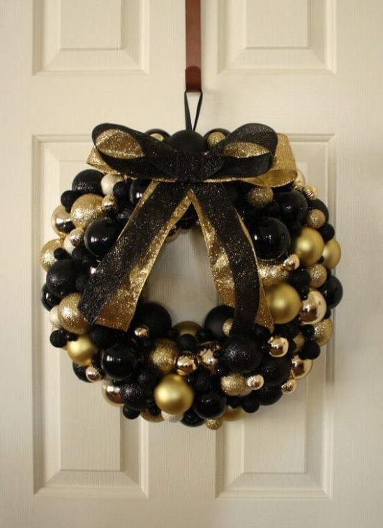 a beautiful black and gold Christmas wreath fully made of ornaments, with matching glitter bows is a gorgeous idea