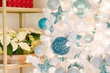 a beautiful coastal Christmas tree with white, silver and turquoise ornaments and beads is a gorgeous idea for a coastal Christmas space