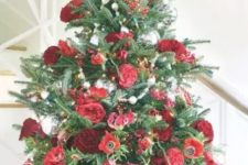 a beautiful tabletop Christmas tree with greenery, red and burgundy fresh flowers plus some silver ornaments is an elegant idea