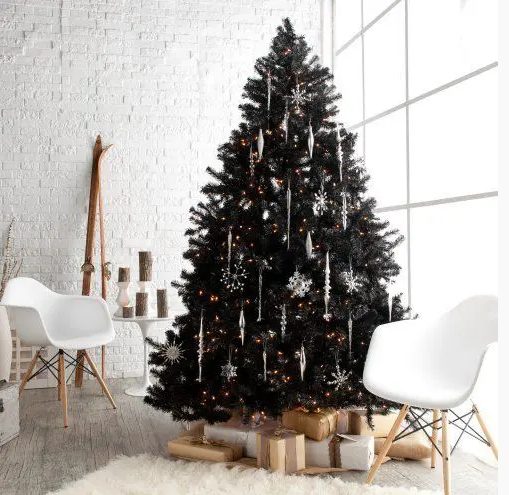 a black Christmas tree with white icicle and snowflake ornaments plus lights is a cool and statement decor idea for a modern or Scandinavian space