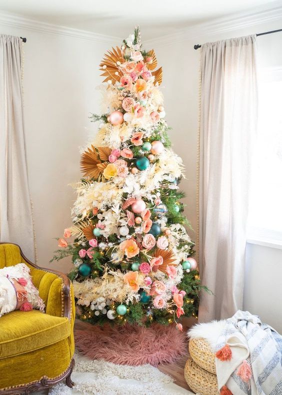 a boho Christmas tree with teal, green and pink ornaments, lights, fronds, pink, yellow blooms and pompoms is a chic idea