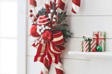 a bold Christmas decoration of candy canes, red and white ornaments, greenery, berries and twigs is a bright and cool solution