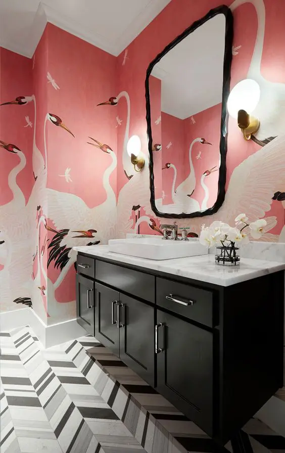 https://i.shelterness.com/2021/11/a-bold-bathroom-with-geometric-tiles-on-the-floor-pink-bird-print-wallpaper-a-black-vanity-a-white-countertop-and-a-sink-and-a-catchy-mirror.jpg
