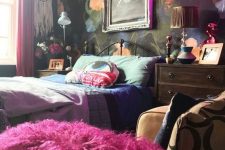 a bold maximalist bedroom with a dark floral accent wall, a metal bed, mid-century modern dressers, bold bedding and a neon light
