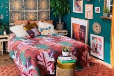 a bold maximalist bedroom with green walls, a bed with a woven headboard, colorful textiles and a bold gallery wall plus statement plants