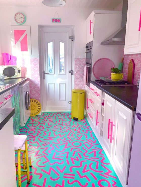 a bold maximalist kitchen with pink color block walls, lilac cabinets, a bold neon printed floor, neon yellow touches