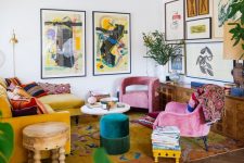 a bold maximalist living room with a mustard sectional, pink chairs, an emerald pouf, a bold gallery wall and a bright rug plus statement plants