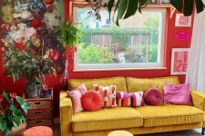 a bold maximalist living room with red walls, a yellow sofa and colorful stools, bold rugs, lovely artworks and potted plants