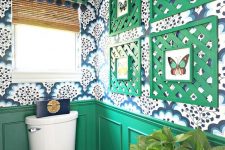 a bold mudroom with green wainscoting, bright printed wallpaper, a bold gallery wall with green frames and a curtain plus metallic touches