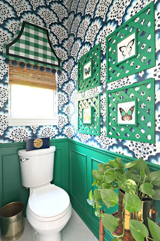 a bold mudroom with green wainscoting, bright printed wallpaper, a bold gallery wall with green frames and a curtain plus metallic touches
