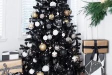 a classy Christmas tree in black with white, black and gold ornaments and stars and lights is all glam and chic