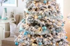 a coastal Christmas tree – a flocked one with silver, light and bright blue ornaments, lights, starfish and a star tree topper is a gorgeous idea