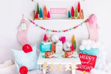 a colorful Christmas nook with shelves with bright bottle brush trees, pink stockings, pastel pillows, peppermint and candy-shaped pillows