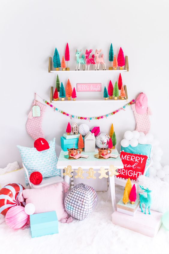 a colorful Christmas nook with shelves with bright bottle brush trees, pink stockings, pastel pillows, peppermint and candy shaped pillows