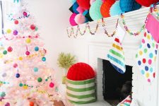 a colorful Christmas space with oversized paper balls, bright stockings, a paper chain garland and a white tree with bright ornaments