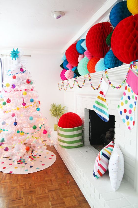 a colorful Christmas space with oversized paper balls, bright stockings, a paper chain garland and a white tree with bright ornaments