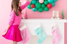 a colorful balloon Christmas wreath over the faux mantel, pastel stockings and some bottle brush trees are gorgeous for holidays