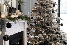 a flocked Christmas tree decorated with black, white and semi sheer ornaments and lights, with a mantel decorated in the same way