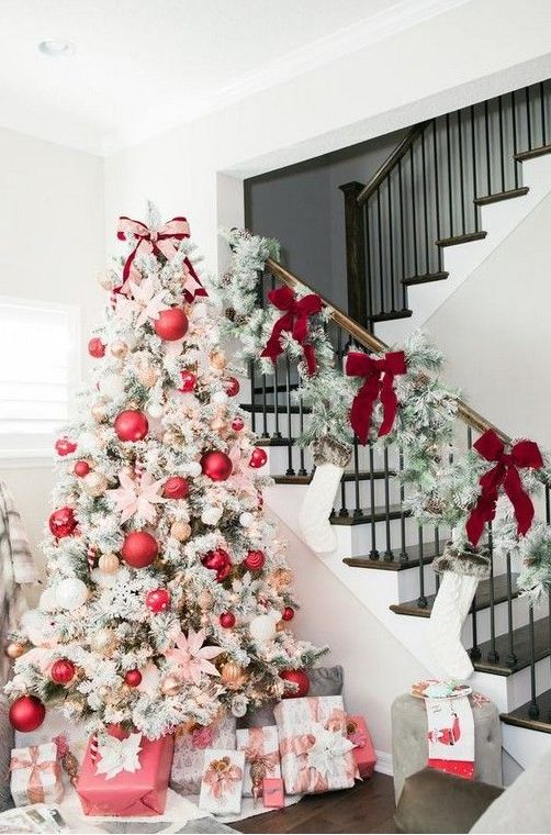 a flocked Christmas tree with lights, oversized pink ornaments and smaller metallic ones plus pink flowers for a glam look