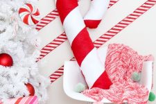 a giant candy cane pillow is a bold and cool decor idea for Christmas, you can DIY it if you can sew a bit