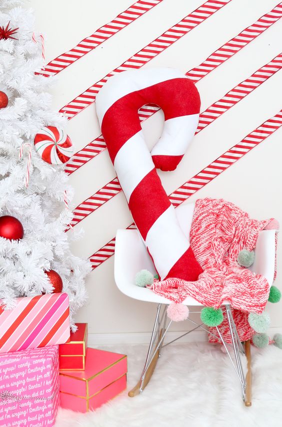 a giant candy cane pillow is a bold and cool decor idea for Christmas, you can DIY it if you can sew a bit