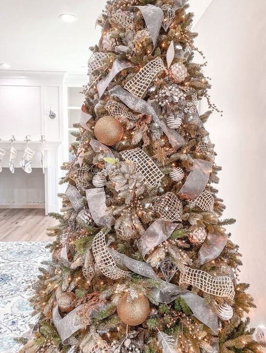 a glam and shiny Christmas tree with metallic ornaments, mesh and metallic ornaments, lights, feathers and sparkles