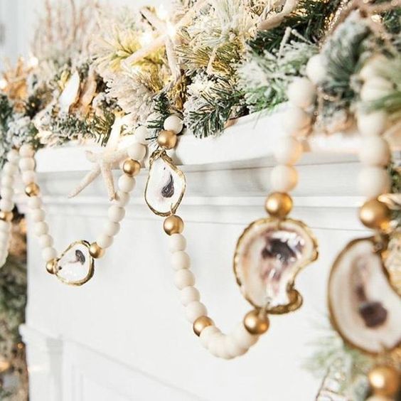 a gorgeous Christmas garland of wooden beads and gilded oysters plus evergreens and starfish are amazing for styling your mantel