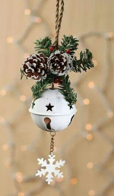 a gorgeous Christmas ornament of a white Christmas bell, a snowflake and some evergreens and snowy pinecones is all cool