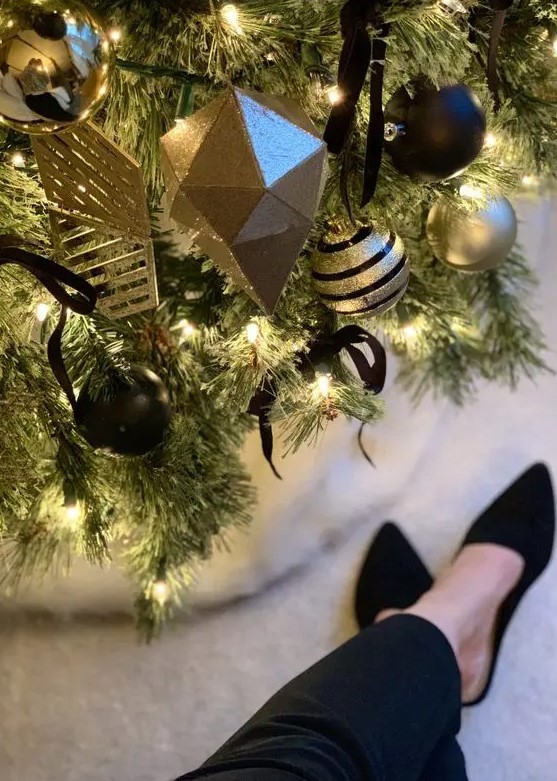 a gorgeous and elegant Christmas tree with lights, gold and black ornaments of geometric shapes and with various patterns