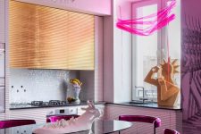 a jaw-dropping maximalist kitchen with white and gold ribbed cabinets, a white tile backsplash, hot pink chairs and crazy sculptures