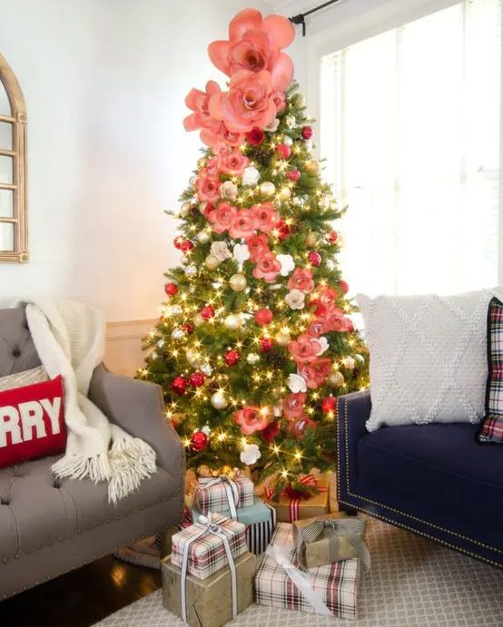 a lovely Christmas tree with silver and red ornaments, pink and white faux flowers of various sizes is beauty and chic