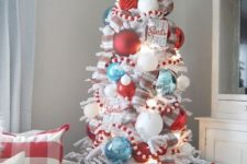 a lovely coastal Christmas tree with oversized blue, red and white ornaments, matching pompoms and corals is amazing and fun