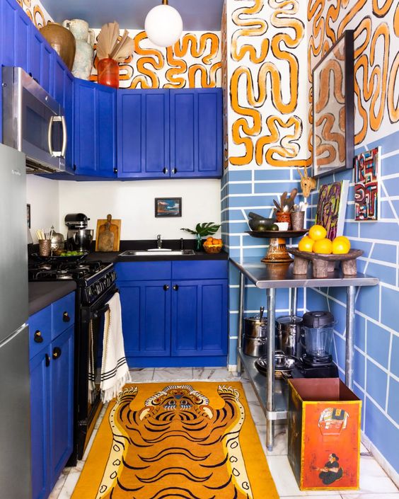 a maximalist bold blue kitchen with pale blue tiles and crazy tiger-inspired prints is a bold and fantastic idea