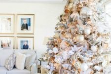 a neutral and metallic Christmas tree with oversized silver ornaments and regular-shaped gold, white ones, fabric blooms and ribbons