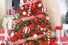 a playful Christmas tree with red and red and white ornaments plus candy cane ones is a cool and bold idea for the space