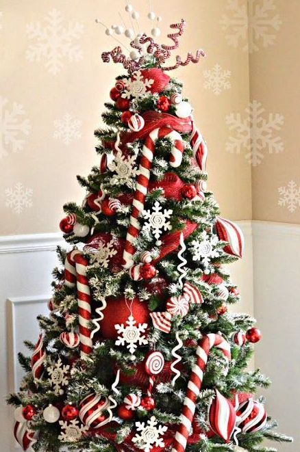 a pretty Christmas tree decorated with red ornaments, white snowflakes, candy canes and swirls on top is a very fun solution