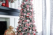 a pretty and cool Christmas tree with red and white ornaments, cupcake, candy cane and peppermint ornaments is a chic idea