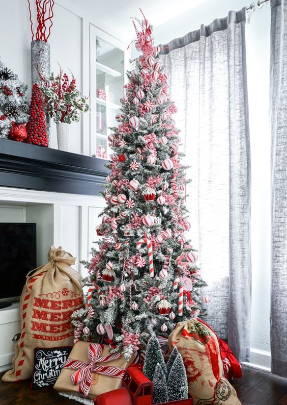 a pretty and cool Christmas tree with red and white ornaments, cupcake, candy cane and peppermint ornaments is a chic idea