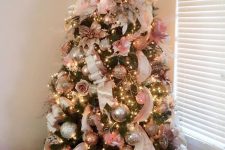 a pretty glam Christmas tree with lights, silver and copper and pink ornaments, branches, twigs, grasses and pinecones