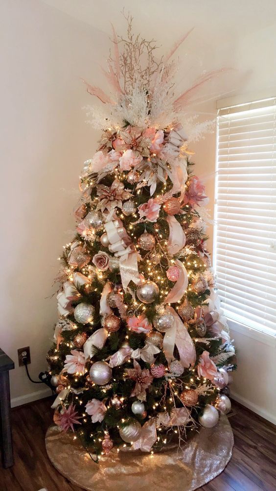 a pretty glam Christmas tree with lights, silver and copper and pink ornaments, branches, twigs, grasses and pinecones