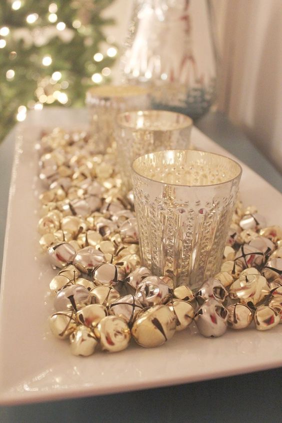 a simple Christmas decoratoin of a tray with jingle bells and mercury glass candleholders is a bold and shiny idea
