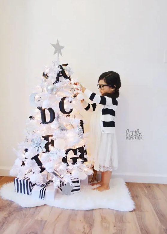 a small white Christmas tree decorated with black letters will help your kids learn them   make such a space for your kids' room