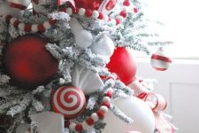 a snowy Christmas tree with candy canes, peppermint, red and white ornaments looks like a giant candy itself and will add fun to your space