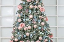 a sophisticated Christmas tree with pastel blue and pink ornaments, blue and pink beads, lights and pink roses is amazing