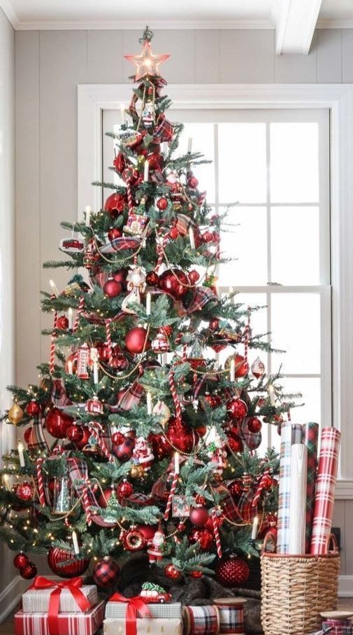 a stylish Christmas tree with red and gold ornaments, some vintage ornaments, beads, candles and candy canes plus a red star on top