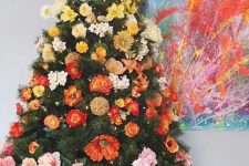 a super bold gradient Christmas tree decorated with faux blooms from yellow to deep red and with lights is beautiful