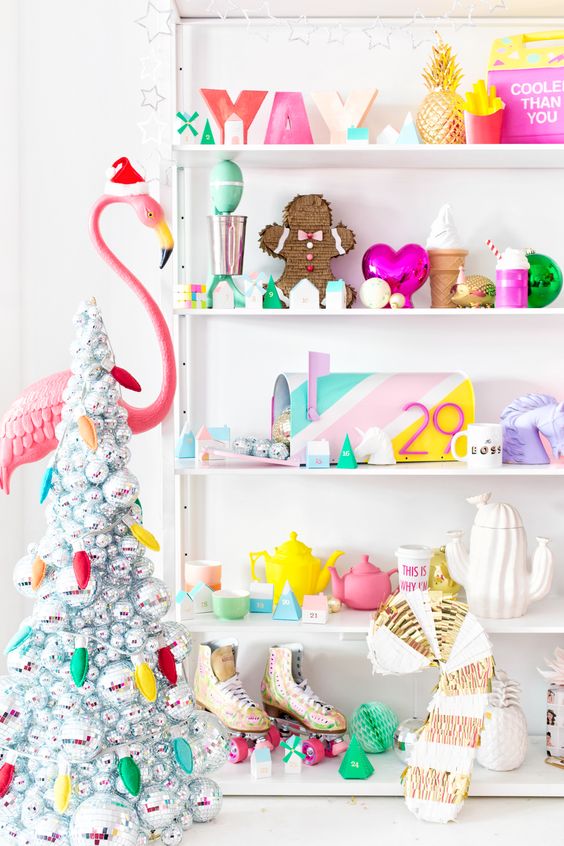 a super cheerful and colorful Christmas nook with colorful letters, gingerbread decor, tableware, a disco ball Christmas tree and a flamingo in a hat