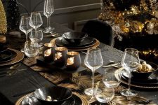 a super glam and shiny Christmas tablescape with a gold feather runner, black and gold porcelain, bottle brush trees