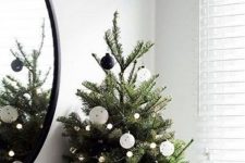 a table Christmas tree with black and white ornaments and pretty lights is a very stylish idea for a Scandinavian space
